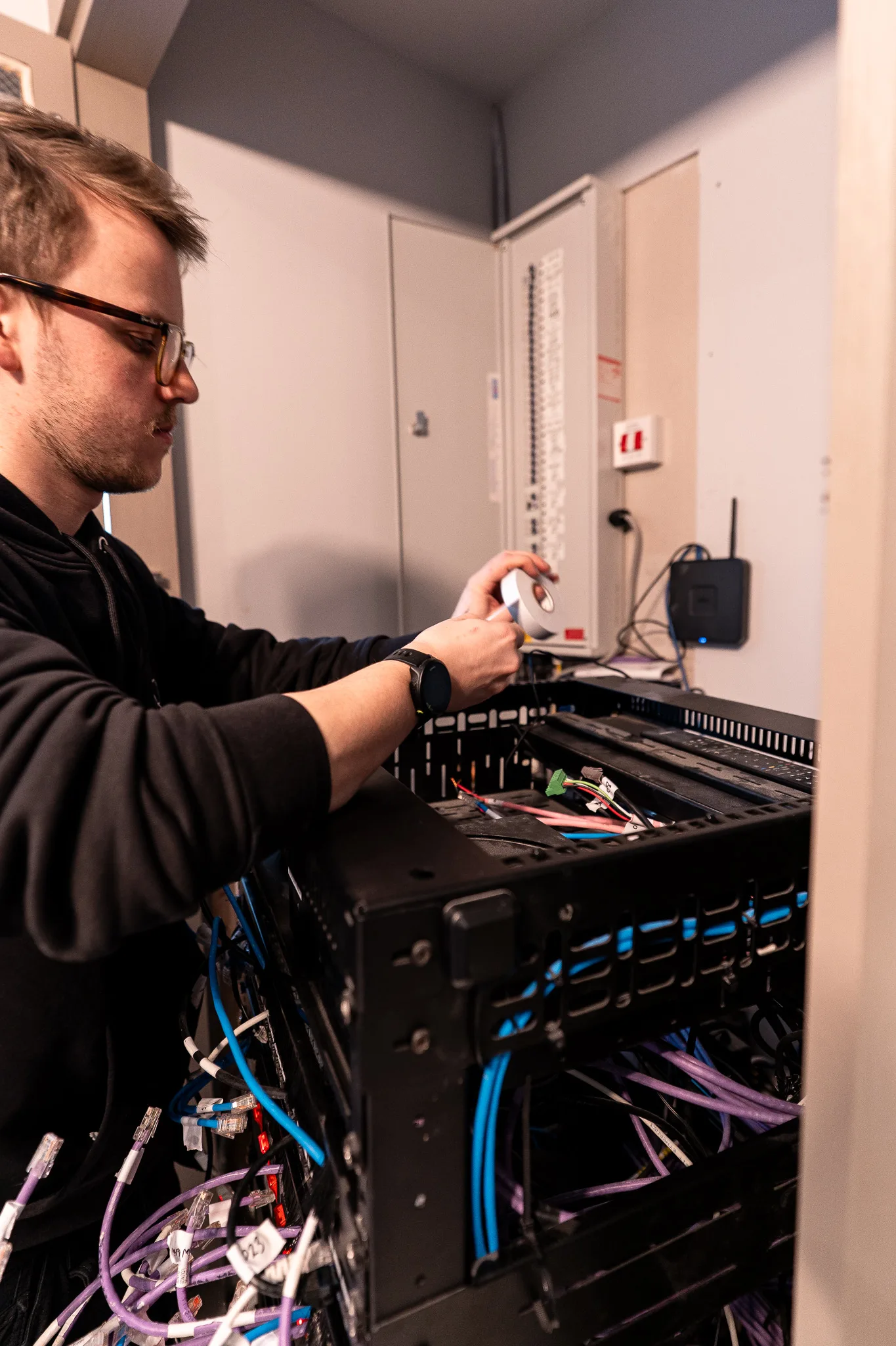 An engineer labelling cable at a rack on site