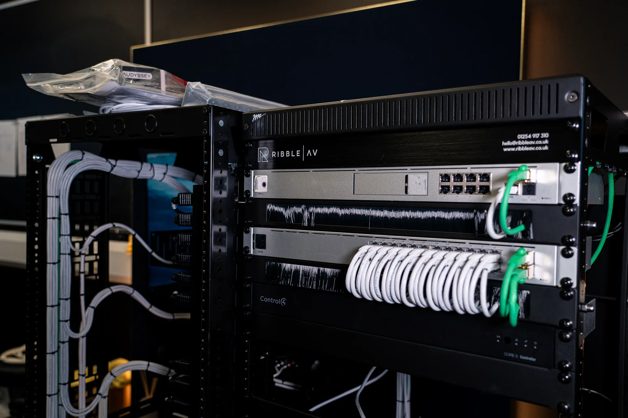 A Ribble AV rack in build, cable dressed and looped, Control4 and network switches racked