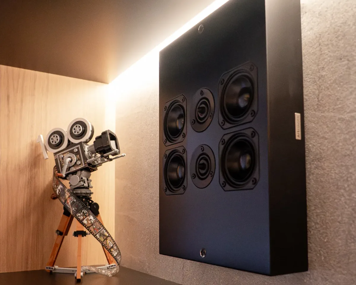 A slimline on-wall loudspeaker mounted flush against plaster in a designed room