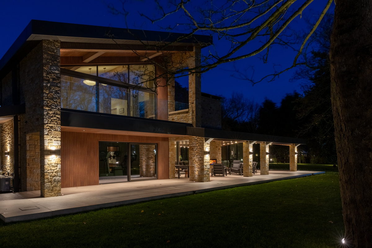 A stone and timber house at dusk, lit by Ribble AV