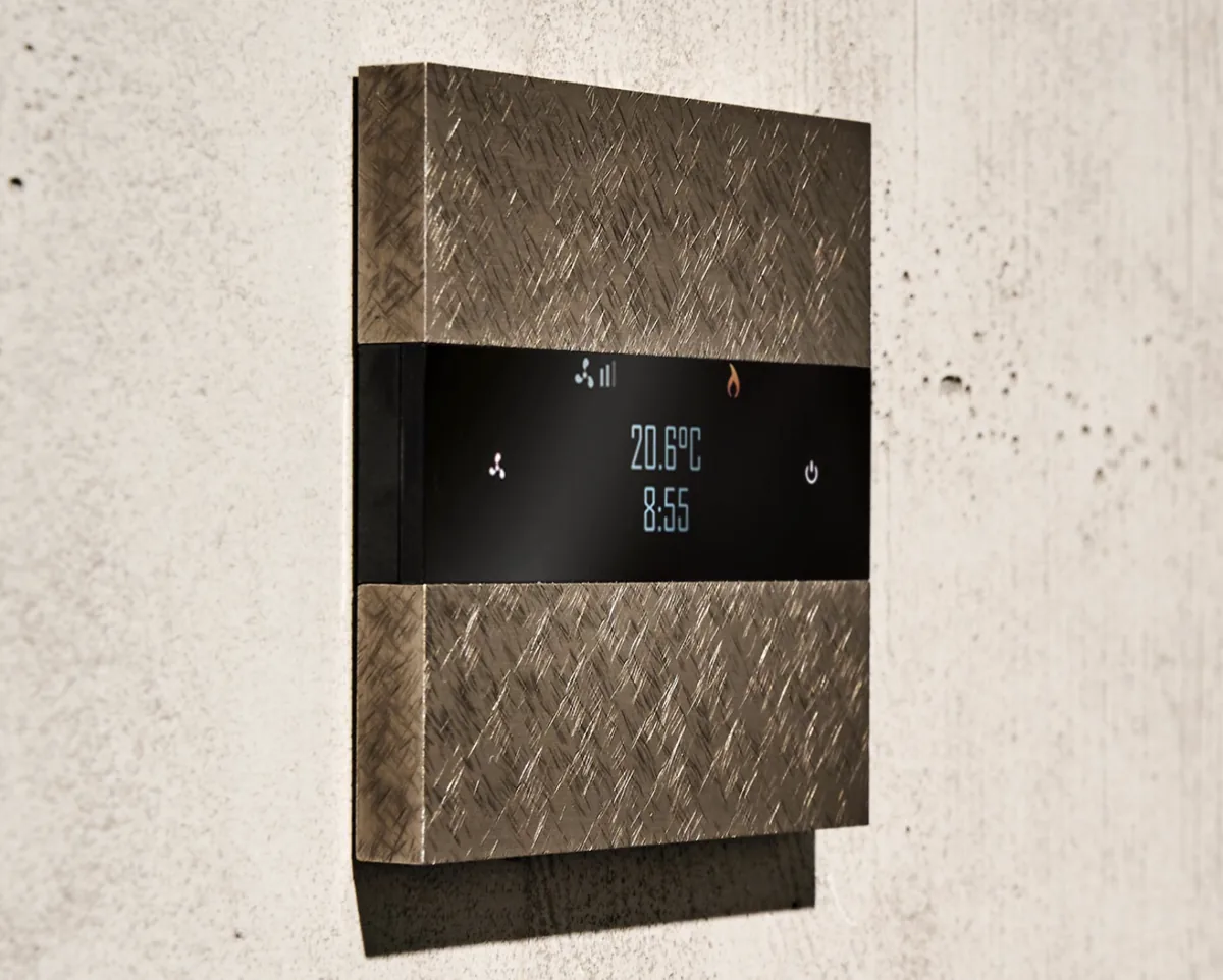 A stone-finished room controller showing temperature