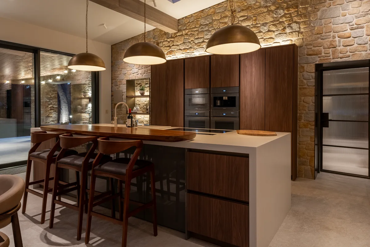 The walnut kitchen island under pendant lighting