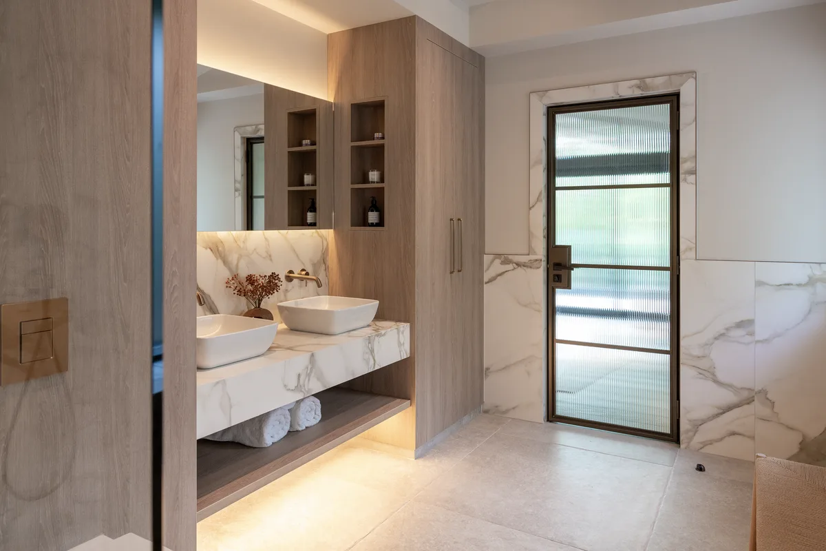 The bathroom with lit vanity and marble