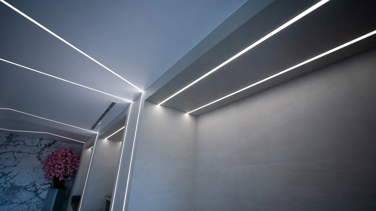 Recessed linear lighting run into a plastered ceiling