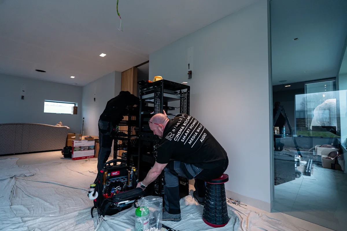 An engineer installing a rack in a finished house