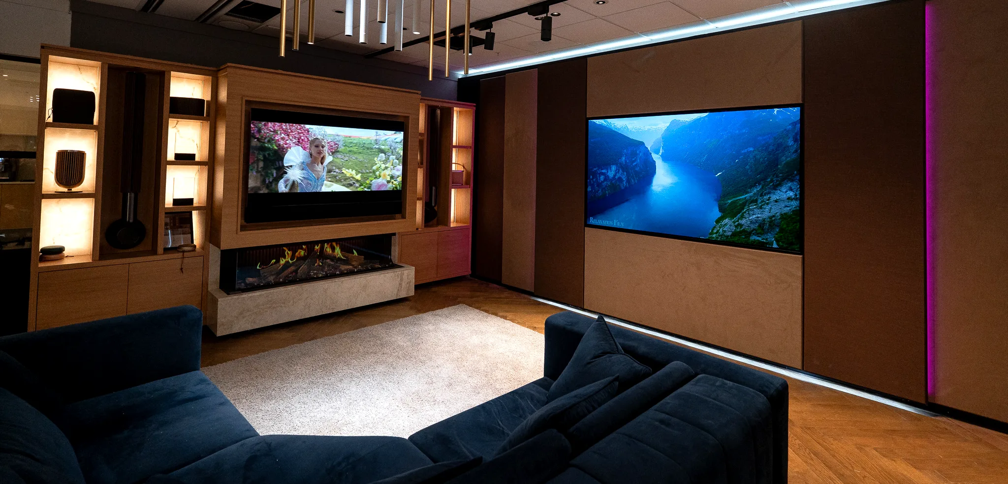 The main demonstration room at the Manchester showroom, with a media wall and fireplace on one side and a large display set into an acoustic fabric wall on the other.
